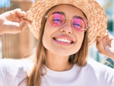 smiling girl in pink glasses and hat