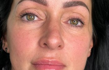 A woman with dark hair is shown from the shoulders up, displaying groomed eyebrows and clear skin. An inset in the lower right corner shows her brows before enhancement.