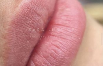 Close-up of healed pink lips displaying even color and smooth texture; text overlay reads "Sara Justice Cosmetic Tattoo Artist.